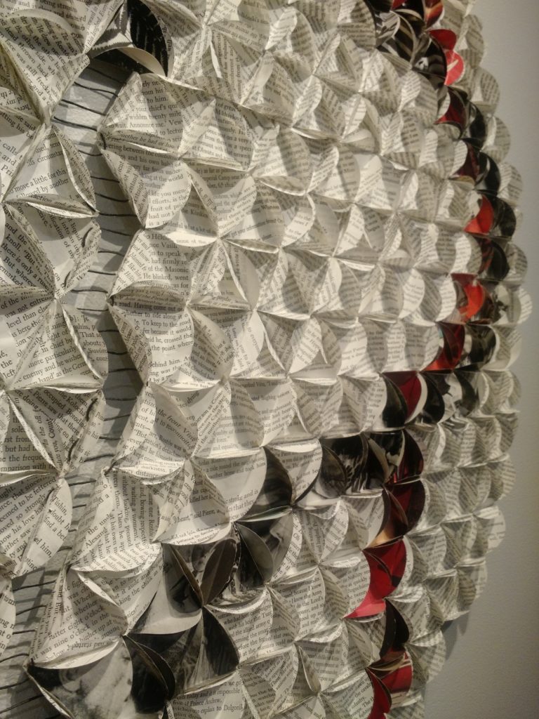 artfully folded book pages, hung on a wall. by Lisa Occhipinti